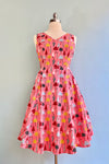  Composed of peach fabric with a print in yellow, grey, red and black patterned umbrellas. This dress has a little give to the fabric which makes it very comfortable to wear.  There is a back zipper, hidden side pockets and is unlined.    Made in the USA